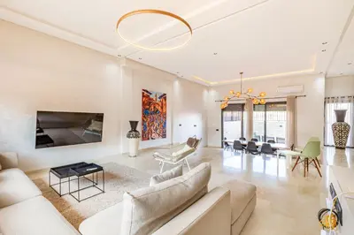 a living room with white furniture and a chandelier at Villa Gina, chic et Moderne avec piscine&terrasse in Marrakech