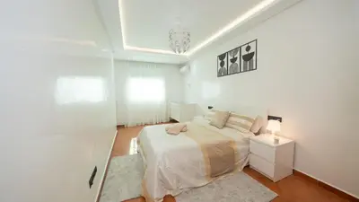 a white bedroom with a bed and a window at Appartement à Marrakech in Marrakech