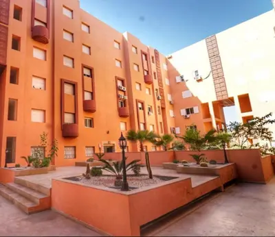 a building with a courtyard with trees in front of it at Appartement à Marrakech in Marrakech
