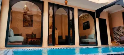 a swimming pool in a house with windows at Riad Sarasvati & SPA in Marrakech