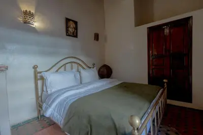 a bedroom with a bed and a red door at Riad Sarasvati & SPA in Marrakech