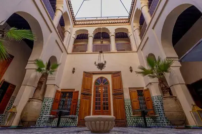 a building with a door and palm trees in it at Riad Sarasvati & SPA in Marrakech