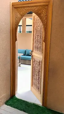 an open door to a living room with a couch at Villa Jassmir 5 chambres 10 min du centre piscine chauffée in Marrakech