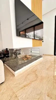 a living room with a fireplace with a tv on the wall at Villa Jassmir 5 chambres 10 min du centre piscine chauffée in Marrakech