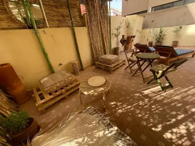 a patio with a table and chairs and a table and a bench at Les Nuits de Miel - Marrakech in Marrakech