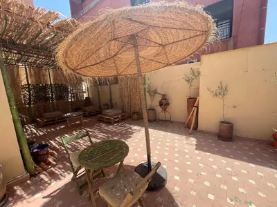 a patio with an umbrella and a table and chairs at Les Nuits de Miel - Marrakech in Marrakech