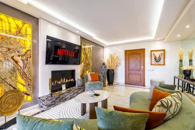 a living room with a couch and a fireplace at Luxury 2-Bedroom Apartment in Hivernage Pool Residence Near Casino in Marrakech