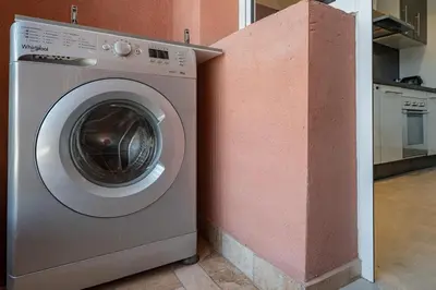 a washing machine sitting next to a pink wall at Luxury Apartment in Marrakech in Marrakech