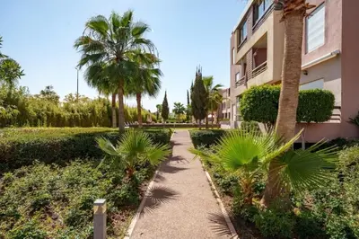 a walkway in front of a building with palm trees at Luxury Apartment in Marrakech in Marrakech