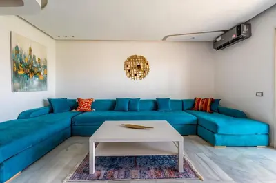 a blue couch in a living room with a table at Luxury Apartment in Marrakech in Marrakech