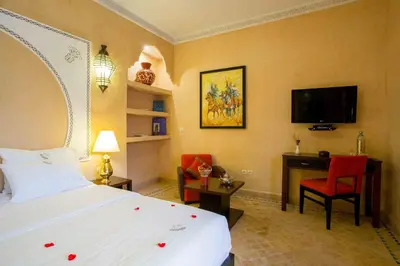a bedroom with a bed and a desk and a tv at Riad Magda & Spa in Marrakech