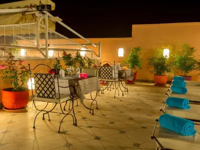 a patio with a table and chairs and plants at Riad Magda & Spa in Marrakech