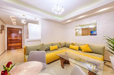 a living room with a yellow couch and a table at Reda location in Marrakech