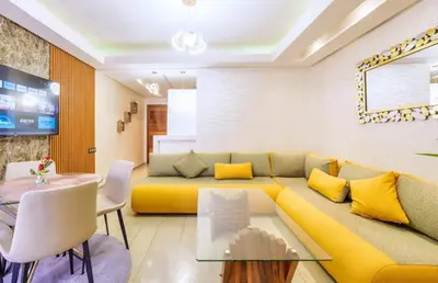 a living room with a yellow couch and a table at Reda location in Marrakech