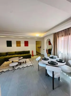 a living room with a couch and tables and chairs at Luxueux 1 Chambre Guéliz Centre in Marrakech