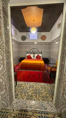 a bedroom with a bed with a red and yellow blanket at Central Marrakesh Medina Apartment in Marrakech