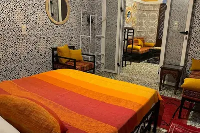 a bedroom with a colorful bed and chairs in it at Central Marrakesh Medina Apartment in Marrakech