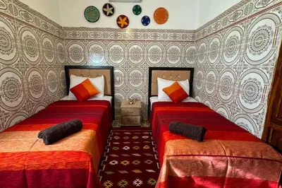 a bedroom with two beds with red and orange at Central Marrakesh Medina Apartment in Marrakech