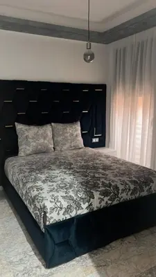 a large bed with a black headboard in a bedroom at Luxueux Appartement-52 - Guéliz Marrakech in Marrakech