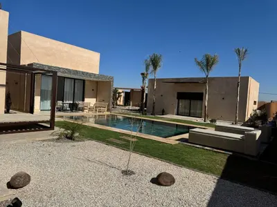 a house with a swimming pool in front of a house at Villa Chafti in Douar Khalifa Ben Mbarek