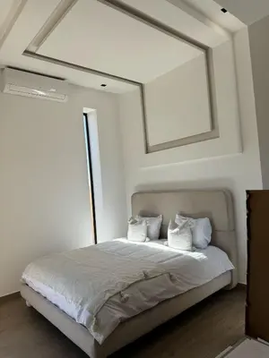 a white bedroom with a bed with a large window at Villa Chafti in Douar Khalifa Ben Mbarek