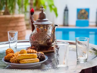 a plate of food on a table with a tea kettle at Riad Chameleon in Marrakech