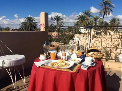 a table with a plate of food on a balcony at Riad Chameleon in Marrakech