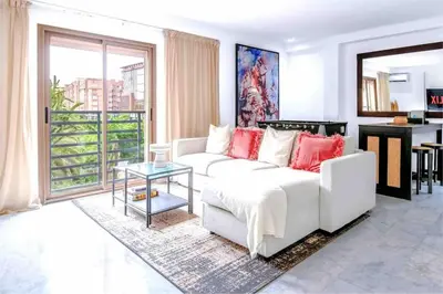 a living room with a white couch and a table at Fun-filled luxury city center apartment in Marrakech
