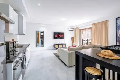 a kitchen and living room with a couch and a table at Fun-filled luxury city center apartment in Marrakech
