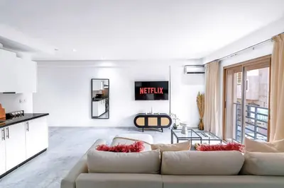 a living room with a couch and a kitchen at Fun-filled luxury city center apartment in Marrakech