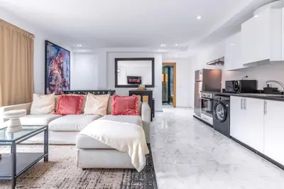 a living room with a couch and a kitchen at Fun-filled luxury city center apartment in Marrakech