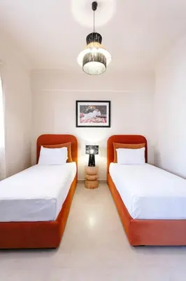 two twin beds in a room with a lamp at Merveille d'Art & Design - Marrakech Downtown in Marrakech