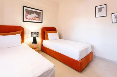 a bedroom with two beds and a lamp in it at Merveille d'Art & Design - Marrakech Downtown in Marrakech