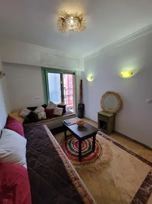a living room with a couch and a table at Top Appartement 1 Rue Yves Saint Laurent for 1-2 Per- Touristes International in Marrakech