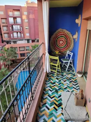 a balcony with chairs and a basket on a balcony at Top Appartement 1 Rue Yves Saint Laurent for 1-2 Per- Touristes International in Marrakech