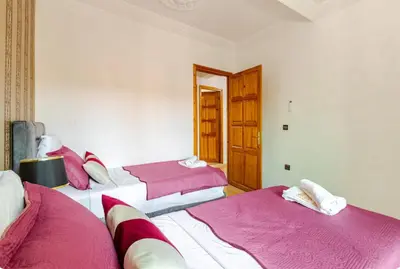 two beds in a room with pink and white sheets at Charming Two-Bedroom Apartment in Gueliz,Marrakesh in Marrakech
