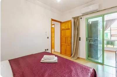 a bedroom with a bed with a red blanket and a window at Charming Two-Bedroom Apartment in Gueliz,Marrakesh in Marrakech