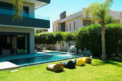 a backyard with a swimming pool and a house at Villa de luxe Avec piscine à Argan Golf Resort in Marrakech