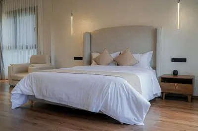 a bedroom with a large white bed and a chair at Villa de luxe Avec piscine à Argan Golf Resort in Marrakech