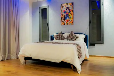 a bedroom with a large bed with a painting on the wall at Villa de luxe Avec piscine à Argan Golf Resort in Marrakech