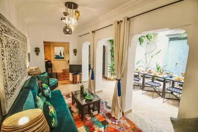 a living room with a green couch and a table at RIAD Dar Argana 100m Place Jemaa el- Fna heated Pool in Marrakech