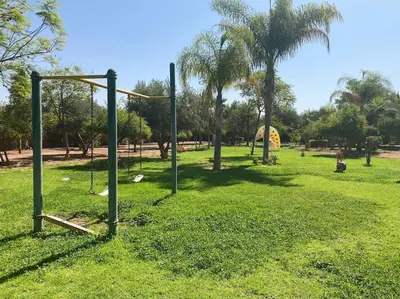 an empty park with a swing set in the grass at Villa Gioia et Luna Garden City-Services All-inConciergerie in Marrakech