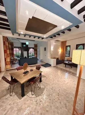 a large living room with a wooden table and chairs at Villa Gioia et Luna Garden City-Services All-inConciergerie in Marrakech