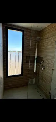 a bathroom with a glass shower and a window at Luxe villa in marrakech in El Makina