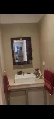a bathroom with a sink and a mirror at Appartement au coeur de Marrakech avec deux piscines et une charmante vue in Marrakech
