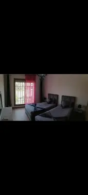 a bedroom with two beds and a window at Appartement au coeur de Marrakech avec deux piscines et une charmante vue in Marrakech