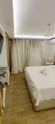 a bedroom with a white bed and a table at Elégant duplex au coeur de Marrakech, Nakhil in Marrakech