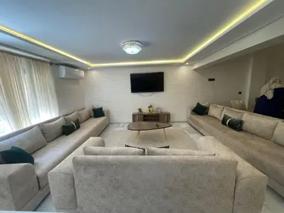 a living room with two couches and a flat screen tv at Elégant duplex au coeur de Marrakech, Nakhil in Marrakech