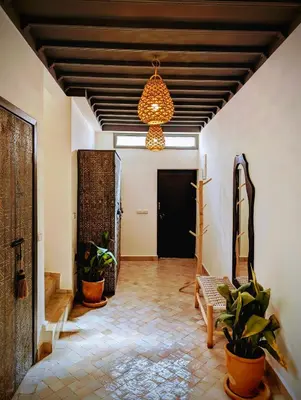 a hallway with plants and a chandelier at Riad LISA 6 personnes in Marrakech