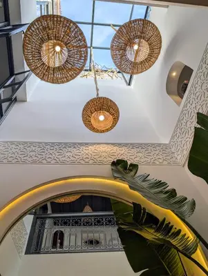 a room with a mirror and chandeliers at Riad LISA 6 personnes in Marrakech